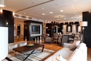 リヤドにあるホリデイ イン メイダンの白いソファとテレビのあるリビングルーム