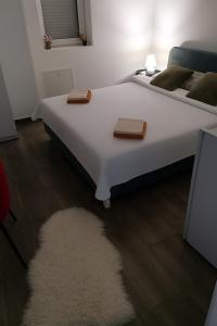 a bedroom with a white bed with a rug at Valencia in Vršac