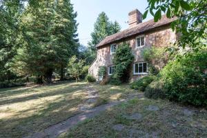 an old stone house in the middle of a field at Large family home based at Westerlands Farm in Graffham