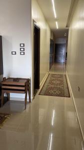 a hallway with a wooden table and a hallway with a door at شقة مفروشة سوبر لوكس علي النيل in Mansoura