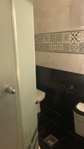 a bathroom with a toilet and a black and white tiles at شقة مفروشة سوبر لوكس علي النيل in Mansoura