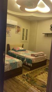 a bedroom with two beds and a ceiling at شقة مفروشة سوبر لوكس علي النيل in Mansoura