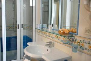 a bathroom with a sink and a mirror and a shower at Appartamenti Amalfi Centro Storico in Amalfi