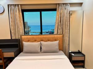 Un dormitorio con una cama y una ventana grande. en Newtown Inn Service Apartment, en Hulhumale