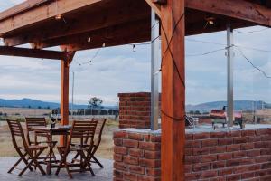 a patio with a table and chairs and a brick wall at Enxe Glamping & Spa  +1 photo