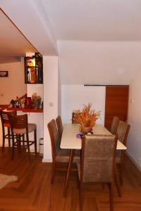 a dining room and kitchen with a table and chairs at Chez Vila in Prizren