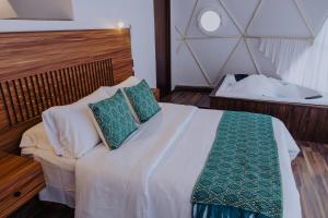 a bedroom with a bed with two pillows on it at Enxe Glamping & Spa 