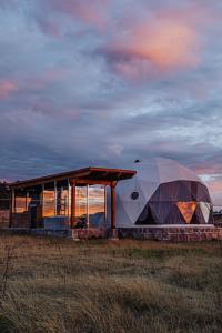 a large dome tent next to a building in a field at Enxe Glamping & Spa 