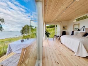a bedroom with a bed and a view of the ocean at Gåsviken - Hven in Sankt Ibb