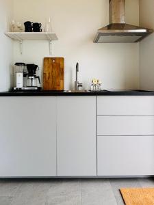 a kitchen with white cabinets and a counter top at Gåsviken - Hven in Sankt Ibb