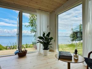 a living room with a table and a large window at Gåsviken - Hven in Sankt Ibb