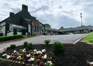 a building with a lot of flowers in a yard at Quarters Inn & Suites in Antioch