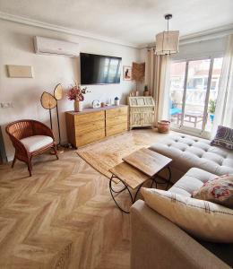 a living room with a couch and a tv at Light Blue Apartment Orihuela Costa in Orihuela Costa