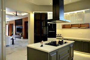 a kitchen with a stove top oven next to at FLORENTINO The Luxury Villa in Amritsar