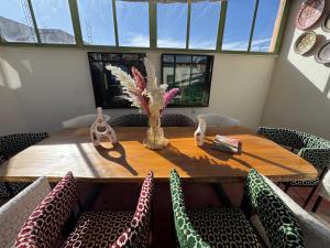 a dining room table with chairs and a vase on it at Riad Dar Tiflet in Marrakech