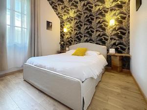 een slaapkamer met een wit bed en een muurschildering bij T2 rénové au coeur de Vendôme avec parking - Le Kozy in Vendôme