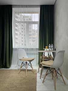 a dining room with a table and chairs and a window at Нові стильні апартаменти в центрі in Mykolaiv