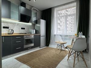 a kitchen with gray cabinets and a table and chairs at Нові стильні апартаменти в центрі in Mykolaiv +7 photos
