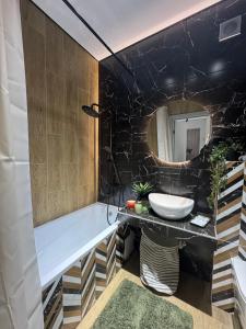 a bathroom with a tub and a sink and a mirror at Нові стильні апартаменти в центрі in Mykolaiv