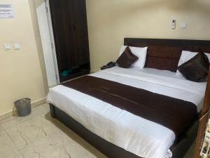 un dormitorio con una cama grande en una habitación en Tracer Wave Cabin, en Akwanga