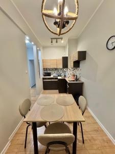 ein Esszimmer und eine Küche mit Tisch und Stühlen in der Unterkunft Pokój przy Parku Róż II in Chorzów
