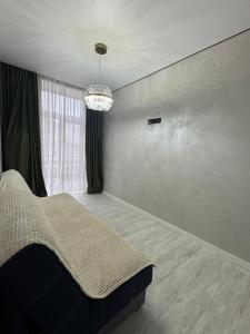 a bedroom with a bed and a chandelier at Нові стильні апартаменти в центрі in Mykolaiv