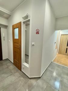 ein leeres Zimmer mit Tür und Flur in der Unterkunft Pokój przy Parku Róż II in Chorzów