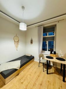 ein Schlafzimmer mit einem Bett, einem Schreibtisch und einem Tisch in der Unterkunft Pokój przy Parku Róż II in Chorzów