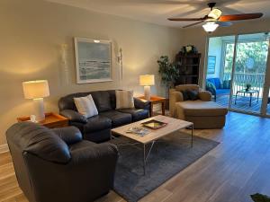 un salon avec un canapé et une table dans l'établissement Fully Remodeled Two Bedroom Condo with shared pool, à Pine Ridge Helistop