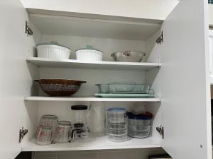 - une étagère de cuisine avec de la vaisselle et d'autres ustensiles dans l'établissement Fully Remodeled Two Bedroom Condo with shared pool, à Pine Ridge Helistop 21 autres photos