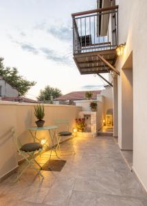 patio con mesa y sillas y balcón en Samis Pelion LuxuryLiving, en Portaria
