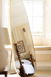 a mirror reflecting a bed in a room at The Bentley Suite in Gileston
