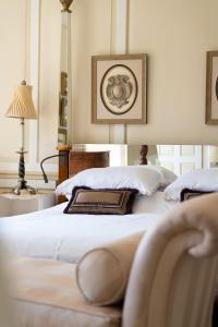 a white bedroom with two beds and a lamp at The Bentley Suite in Gileston