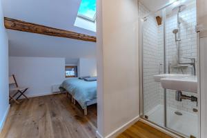 a bathroom with a bed and a sink and a shower at Chalet des Granges in Saint-Marcel