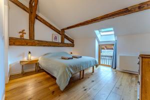 a bedroom with a bed and a wooden floor at Chalet des Granges in Saint-Marcel