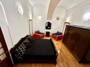 ein Schlafzimmer mit einem Bett und Stühlen in einem Zimmer in der Unterkunft Ada Old Town Apartments 3 in Braşov