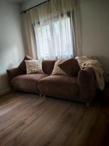 eine Couch in einem Wohnzimmer mit Fenster in der Unterkunft Ca l'Eli Caseta in Montblanc