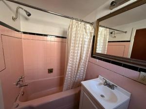 a bathroom with a sink and a tub and a mirror at Springs Inn by Capital O I 25 in Colorado Springs +32 photos