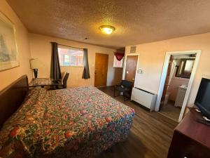 a hotel room with a bed and a television at Springs Inn by Capital O I 25 in Colorado Springs