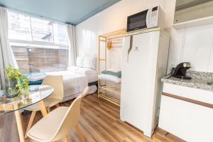 a small room with a bed and a table and chairs at Marco Zero Containers - Próximo à Roda Gigante in Balneário Camboriú