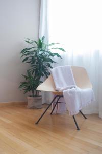 a chair with a blanket on it next to a plant at Dimore Romano in Lecce