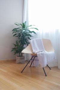 ein Stuhl mit einer Decke neben einer Pflanze in der Unterkunft Dimore Romano in Lecce