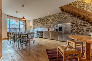 a kitchen and dining room with a stone wall at Chalet des Granges in Saint-Marcel