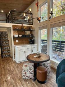 une chambre avec une table et une cuisine avec des fenêtres dans l'établissement Blueberry Farm Cottage, Hot Tub, Creek, Game Room, à Mentone