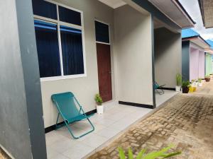 einem blauen Stuhl auf der Außenseite eines Hauses in der Unterkunft D-Civya Home and Apartment in Morogoro