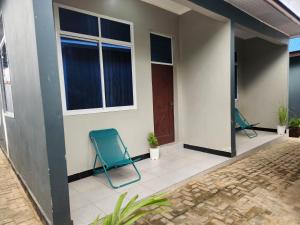 zwei blaue Stühle auf der Veranda eines Hauses in der Unterkunft D-Civya Home and Apartment in Morogoro