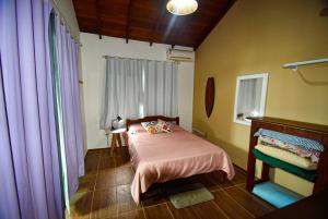 フロリアノポリスにあるMozamba Surf Houseのベッドルーム1室(ピンクの毛布付きのベッド1台付)