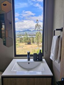 NemocónにあるVive Rela Tiny Housesの- 野原の景色を望む窓付きのバスルームシンク