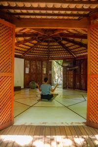 a man is sitting on the floor in a room at Recanto da Mata Pipa in Pipa