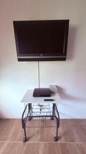 a white table with a flat screen tv on a wall at Habitación 3 en Villa Mariaclaudia in Macas